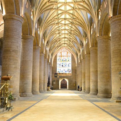The interior of Tewkesbury Abbey showing the arched ceiling and pillars