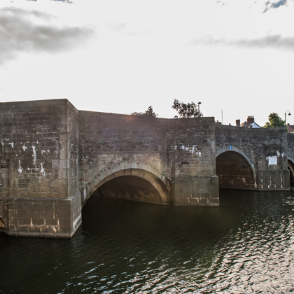 a low arched stone bridge in Tewkesbury crossing the Severn